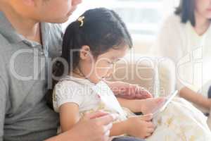 Father and daughter playing with digital tablet.