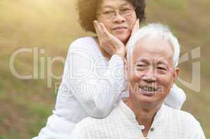 Old Asian couple smiling outdoor.