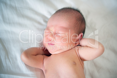 Newborn baby wakes up and stretches