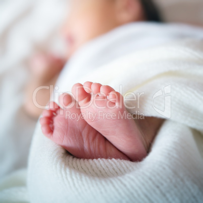 Newborn baby feet in bed