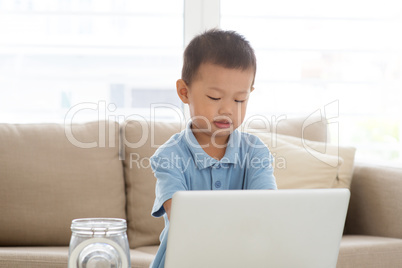 Asian boy using computer laptop.