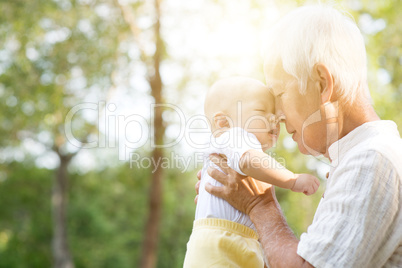 Grandfather kissing grandson.