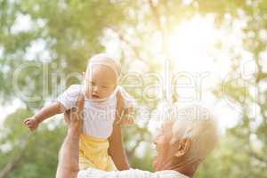 Grandfather playing with grandson at park.