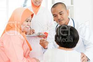 Doctor checking temperature of sick children