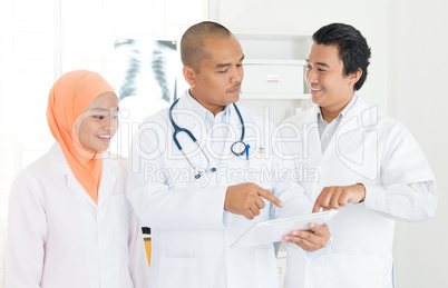 Medical doctors discussing on tablet pc