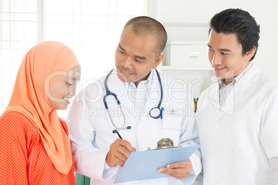 Medical doctor showing health report to patient.