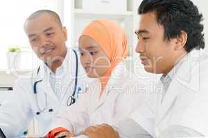 Asian medical team discussing at hospital office.