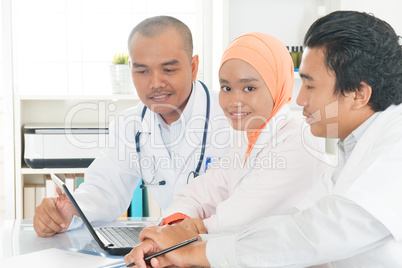 Medical team discussing at hospital office.