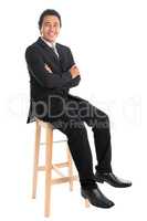Full body Asian businessman arm crossed sitting on chair