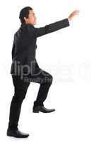 Full body Asian businessman hand reaching high