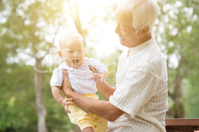 Grandfather with grandson at park.