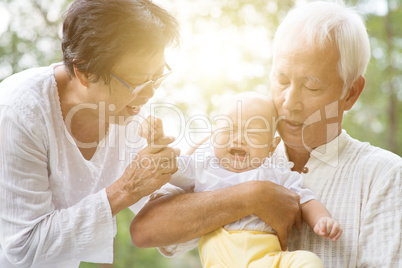 Grandfather, grandmother and grandson outdoors.