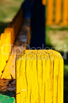 Yellow wooden post close up.