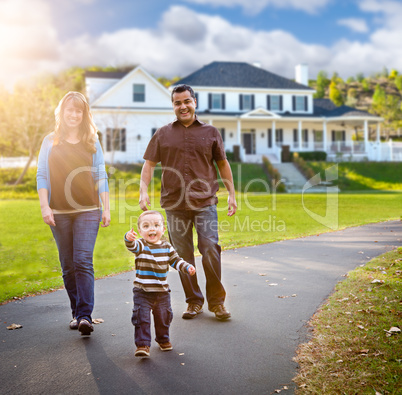 Happy Mixed Race Family Walking in Front of Beautiful Custom Hom