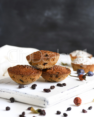 baked cupcakes with raisins on a white wooden board