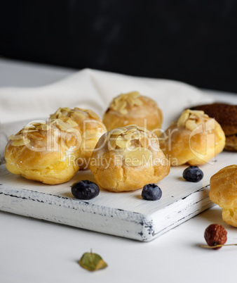 baked profiteroles with custard are sprinkled with almonds