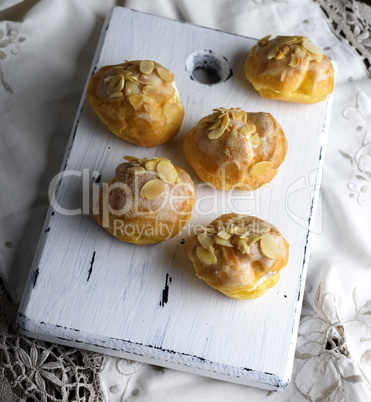 baked profiteroles with custard sprinkled with almonds