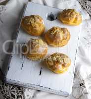 baked profiteroles with custard sprinkled with almonds