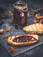 raspberry jam with a glass jar and slices of white bread