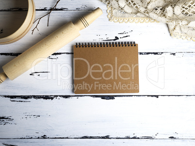 empty paper notepad, wooden rolling pin and a sieve