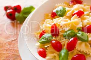 Closeup of Farfalle pasta with cherry tomatoes and basil