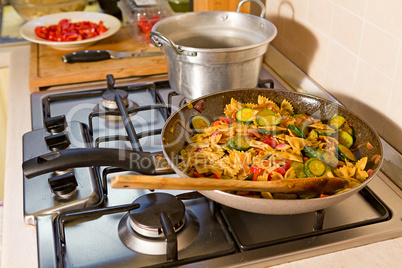 Whole farfalle pasta with zucchini, cherry tomatoes and red onio