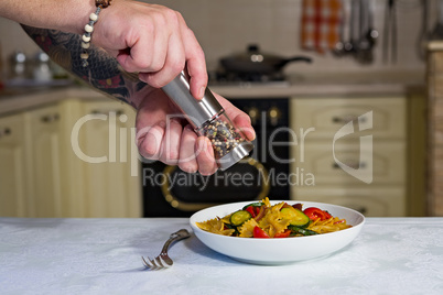 Whole farfalle pasta with zucchini, cherry tomatoes and red onio