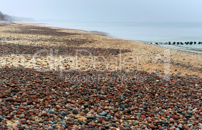 small stones on the coast, low waves run into the sea coast, Sea waves on the beach, a storm in the Baltic sea,