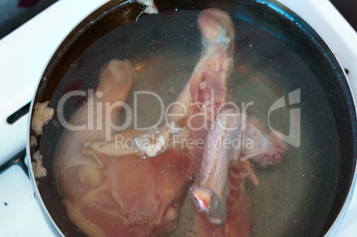 chicken broth, chicken cooked, chicken carcass in water in a saucepan