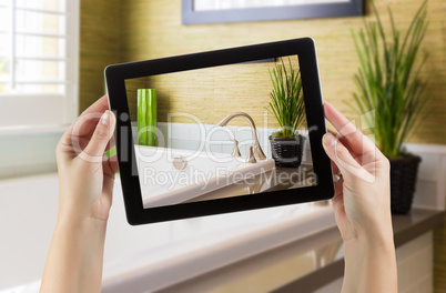 Female Hands Holding Computer Tablet In Bathroom with Photo on S