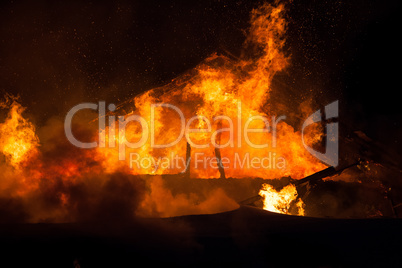 Burning fire flame on wooden house roof