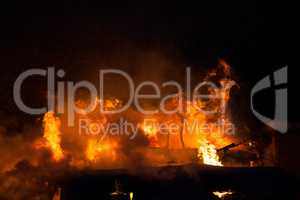 Burning fire flame on wooden house roof