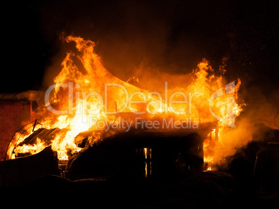 Burning fire flame on wooden house roof