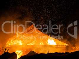 Burning fire flame on wooden house roof