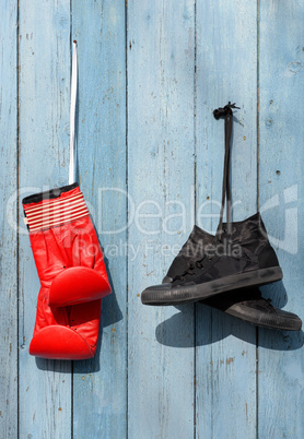 Black textile worn sneakers and red leather boxing gloves