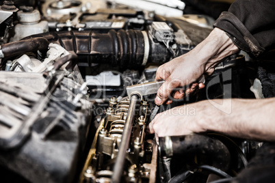 Automobile service worker or garage mechanic repairing auto car engine