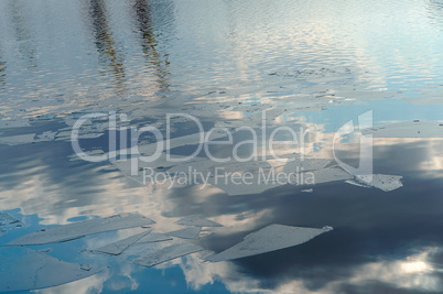 spring, reflection clouds water, ice floats, sun and clouds reflected in ice floes and water