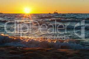 sunset on the sea, the waves beat against the breakwater, the sea at dawn, the ships on the horizon