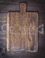 very old brown kitchen cutting board with handle