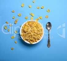 cornflakes in a white ceramic plate and an iron spoon