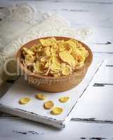 cornflakes in a wooden bowl on a white board