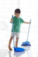 Asian child sweeping floor