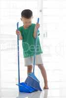 Young boy sweeping floor