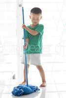Asian boy mopping floor