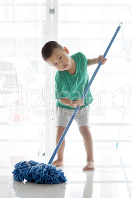 Asian child mopping floor