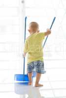 Asian toddler sweeping floor