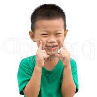 Asian child pointing his cheeks