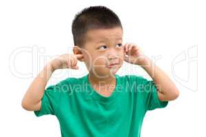 Asian boy covered ears looking away