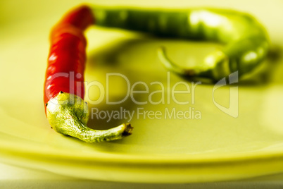 Red and green hot pepper on dish.