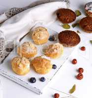 profiteroles with white cream and cupcakes with raisins